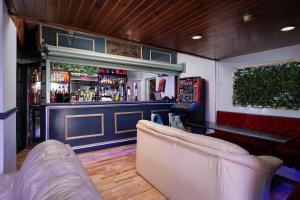 a bar with two couches in front of a bar at 100 Pipers Hotel in Blackpool
