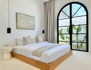 a bedroom with a large bed with a large window at Melrose x The Young Villas in Uluwatu +78 photos