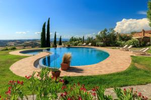 a large swimming pool in a yard with a patio at Dimora Santa Margherita - Boutique Hotel in Cinigiano