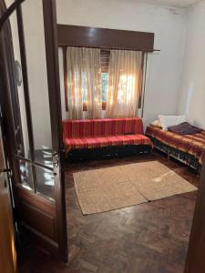 ein Wohnzimmer mit einem roten Sofa und einem Fenster in der Unterkunft CASA Mito in Río Cuarto