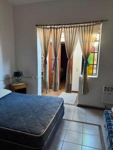 ein Schlafzimmer mit einem Bett und einem Fenster in der Unterkunft CASA Mito in Río Cuarto
