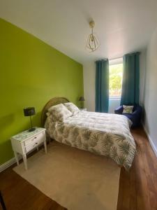 a bedroom with a bed and a night stand with a table at Le Grand 27 in Guebwiller