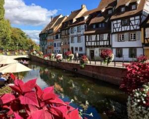 a group of buildings next to a river at Le Grand 27 in Guebwiller