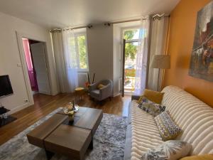 a living room with a white couch and a coffee table at Le Grand 27 in Guebwiller