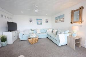 a living room with a blue couch and a tv at Harbour View - Sleeps 26 guests in Liscannor
