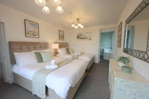 a bedroom with two beds and a bathroom at Harbour View - Sleeps 26 guests in Liscannor