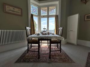 a dining room with a table and chairs and a window at The Vicar's View at the Old Vicarage in Lincoln