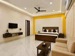a bedroom with a bed and a tv and a couch at Kanha Green in Habībganj