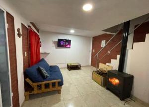 a living room with a blue couch and a fireplace at Cabañas Pá Que te Vengas in Trapiche