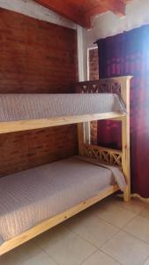 two wooden bunk beds sitting in a room at Cabañas Pá Que te Vengas in Trapiche +1 photo