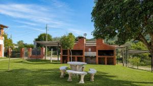 a group of benches in a yard with a building at Cabañas Pá Que te Vengas in Trapiche
