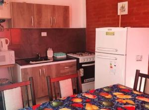 a kitchen with a white refrigerator and a table at Cabañas Pá Que te Vengas in Trapiche