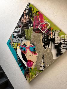 a painting of a woman with glasses on a wall at Hotel Kreuzplatz Gießen Zentrum in Gießen