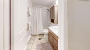 a white bathroom with a toilet and a sink at Snow Ghost Inn 220 by Okanagan Premier in Big White +12 photos