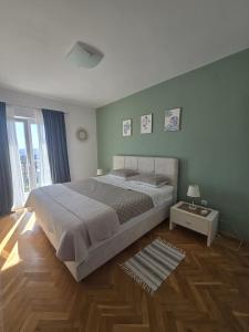 a bedroom with a large bed and a wooden floor at Villa Joy- Paradise near Split by Istra Vacation in Kučine
