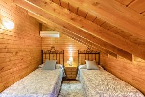 two beds in a room with wooden walls at Buhardilla Armonia Rural in Granadilla de Abona +12 photos