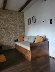 a living room with a wooden couch in a room at BODZA Apartment in Tompa