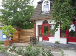a small house with a red door and window at BODZA Apartment in Tompa