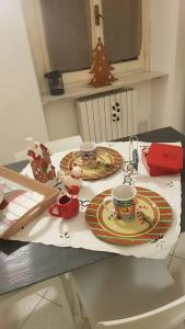 a table with two plates and two cups on it at Casa della Ludo Biella in Biella +12 photos