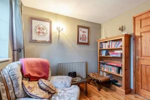 a living room with a chair and a book shelf at 3 Bed in Lincoln oc-90396 in Washingborough