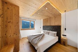 a bedroom with a large bed with a wooden ceiling at Chalet Bucher in Rifiano +31 photos