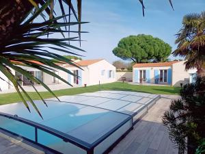a tennis court in front of a house at La Barjuline - Île d'Oléron in La Brée-les-Bains
