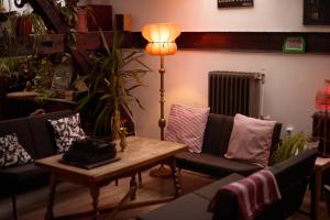 a living room with couches and a table with a lamp at Das Nest Budapest in Budapest