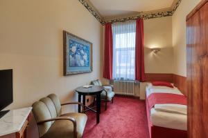 a hotel room with a bed and a table and chairs at Hotel Continental in Pilsen +50 photos