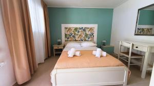 a bedroom with a bed with two towels on it at Chrissa Camping Rooms & Bungalows in Delphi +49 photos