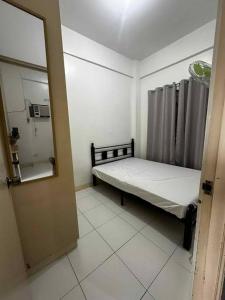 a small room with a bed and a mirror at Bautista Apartments in Imus