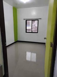 a room with a window and a white wall at Bautista Apartments in Imus