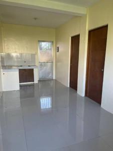 an empty room with a kitchen and two doors at Bautista Apartments in Imus