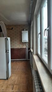an empty kitchen with a refrigerator and windows at Saraharth in Alaverdi