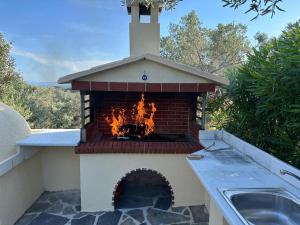 a outdoor pizza oven with a fire in it at Villa in Skiathos in Skiathos