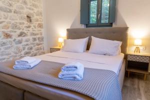 a bedroom with a bed with towels on it at Mainotti's house with balcony in Areopoli