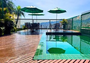 a swimming pool with umbrellas and a table and chairs at Dayrell Hotel e Centro de Convenções in Belo Horizonte