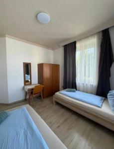 a bedroom with two beds and a desk in it at Wohung Leonard in Schwanenstadt