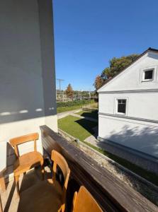 a balcony with two chairs and a white building at Wohung Leonard in Schwanenstadt +10 photos