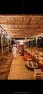 a group of people walking under a wooden structure at Omi Farm & Lodge in Marrakesh