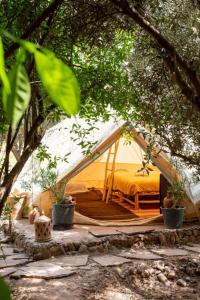 a tent with a bed in the middle of trees at Omi Farm & Lodge in Marrakesh +24 photos