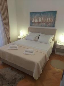 a bedroom with a large bed with two towels on it at Apartman Matilda in Gradac
