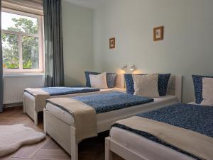 a room with three beds and a window at Apartmány penzion Jasmín in Liberec