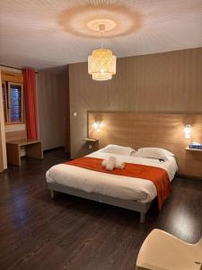 a bedroom with a large bed and a chandelier at La Tour Des Lys in Maubeuge +21 photos