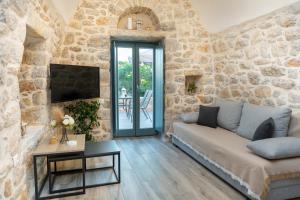 a living room with a couch and a stone wall at Mainotti's house with balcony in Areopoli