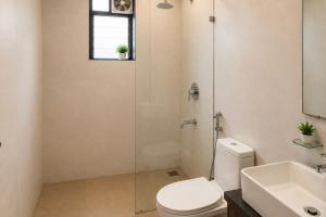 a bathroom with a shower and a toilet and a sink at Shiva Apartments & Stud!os GOA in Parra +19 photos