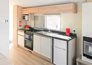 a kitchen with a sink and a stove top oven at Beech Hedge in Coupar Angus
