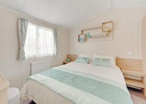 a white bedroom with a large bed and a window at Beech Hedge in Coupar Angus