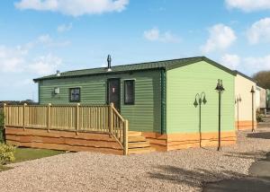 a green house with a wooden deck in a driveway at Beech Hedge in Coupar Angus +31 photos