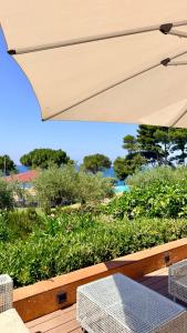 a patio with a table and a white umbrella at Villa Edo Cefalù in Cefalù