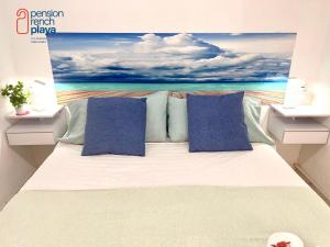 a bedroom with a bed with a painting on the wall at Pensión RENCH in Alcossebre